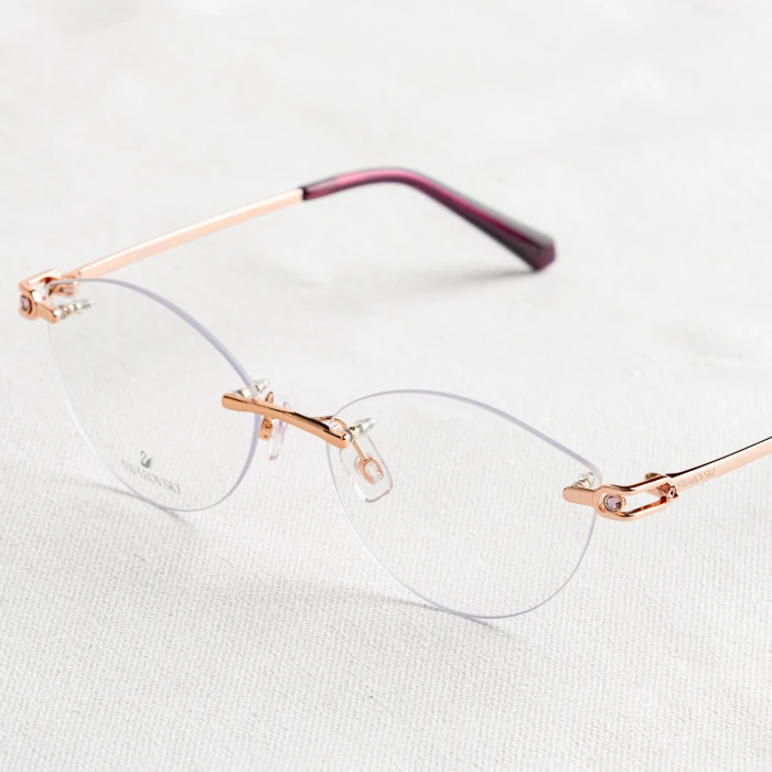 Rimless spectacles with golden frame on a white carpet